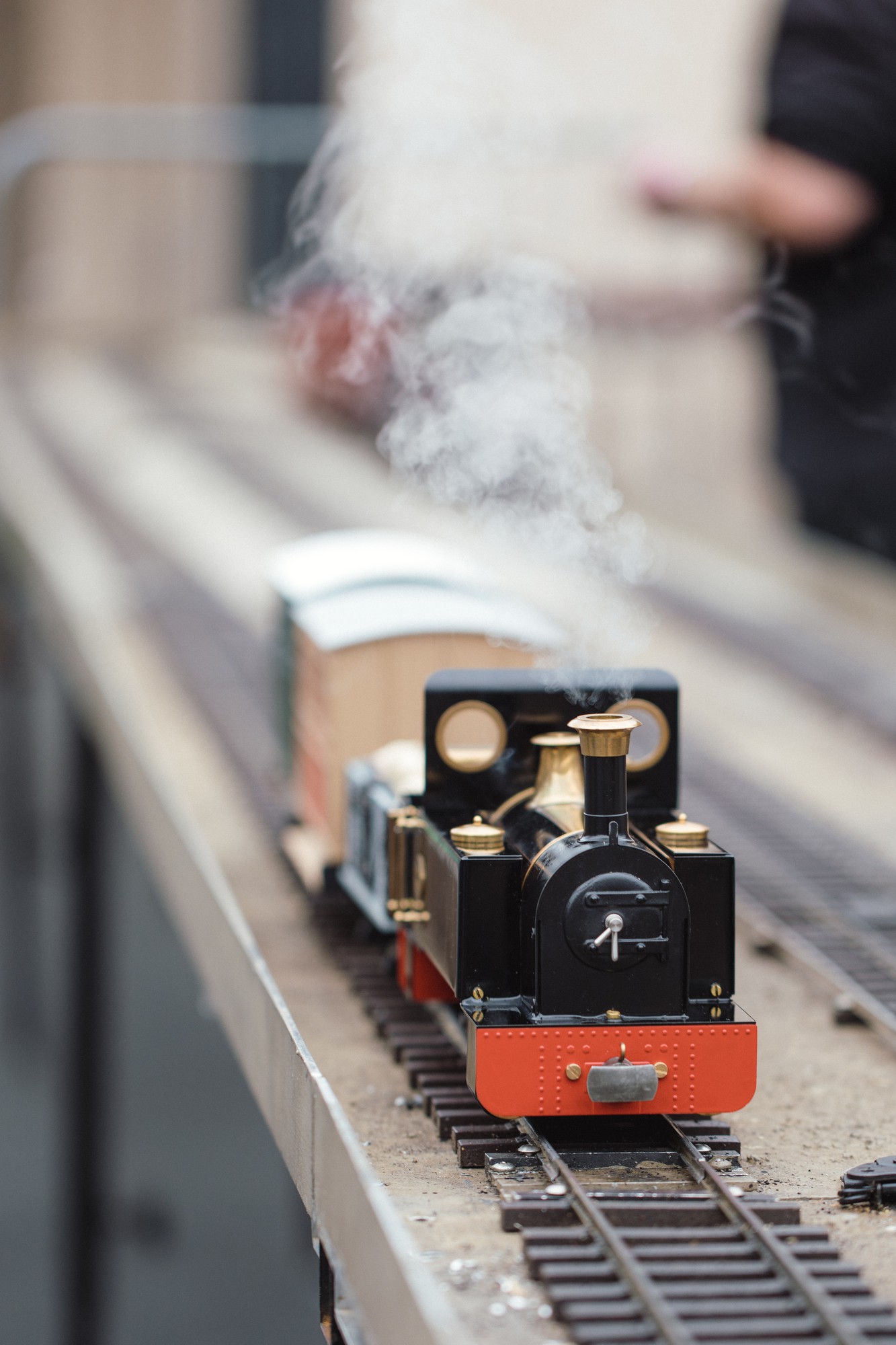 Trem em miniatura chegando à plataforma de uma estação